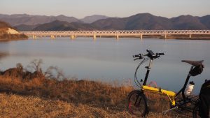 The sun sets over a bridge on the ride between Seoul and Busan in Korea